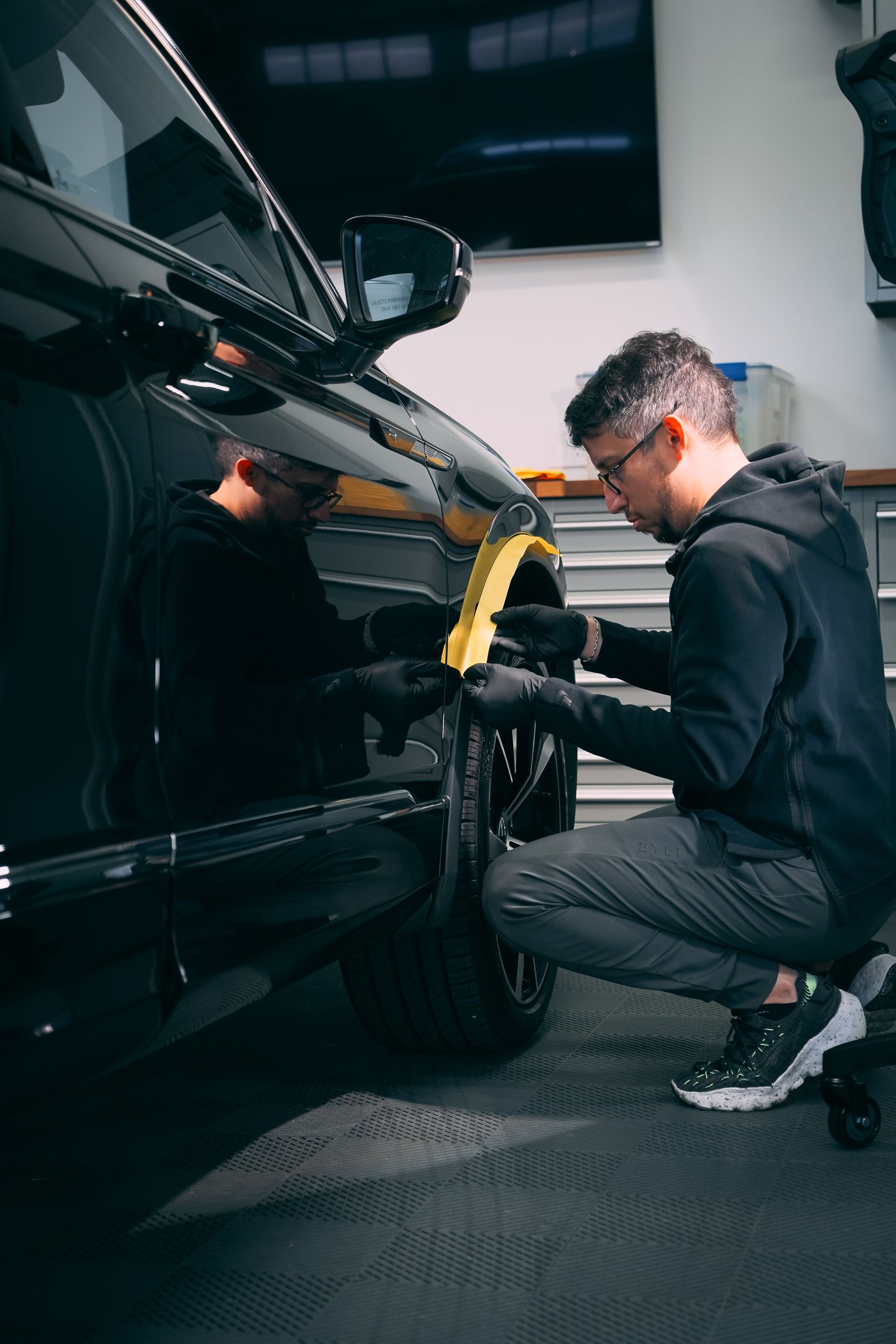 A man is working on a car in a garage.