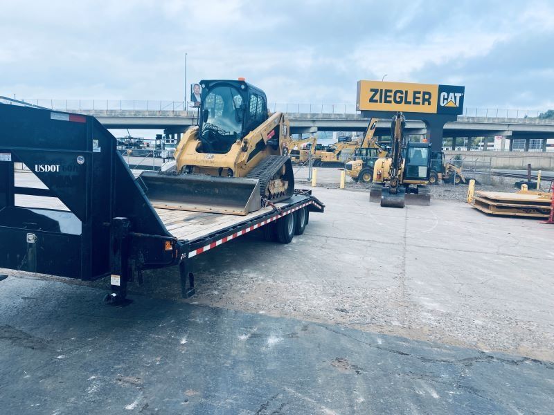Yellow CAT skid steer on trailer at Ziegler CAT equipment dealership.