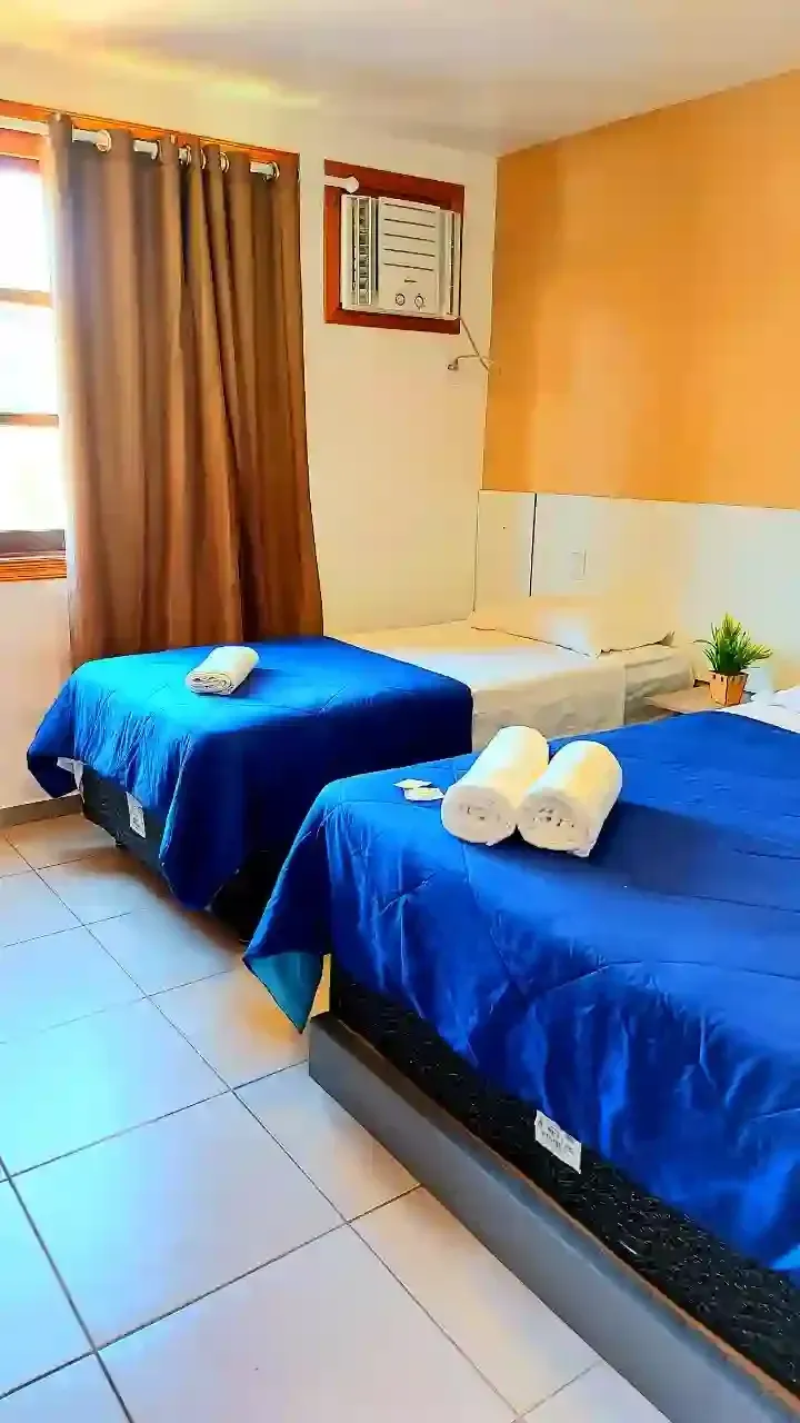 Um quarto de hotel com duas camas e uma janela-pousada-itacuruca-inn