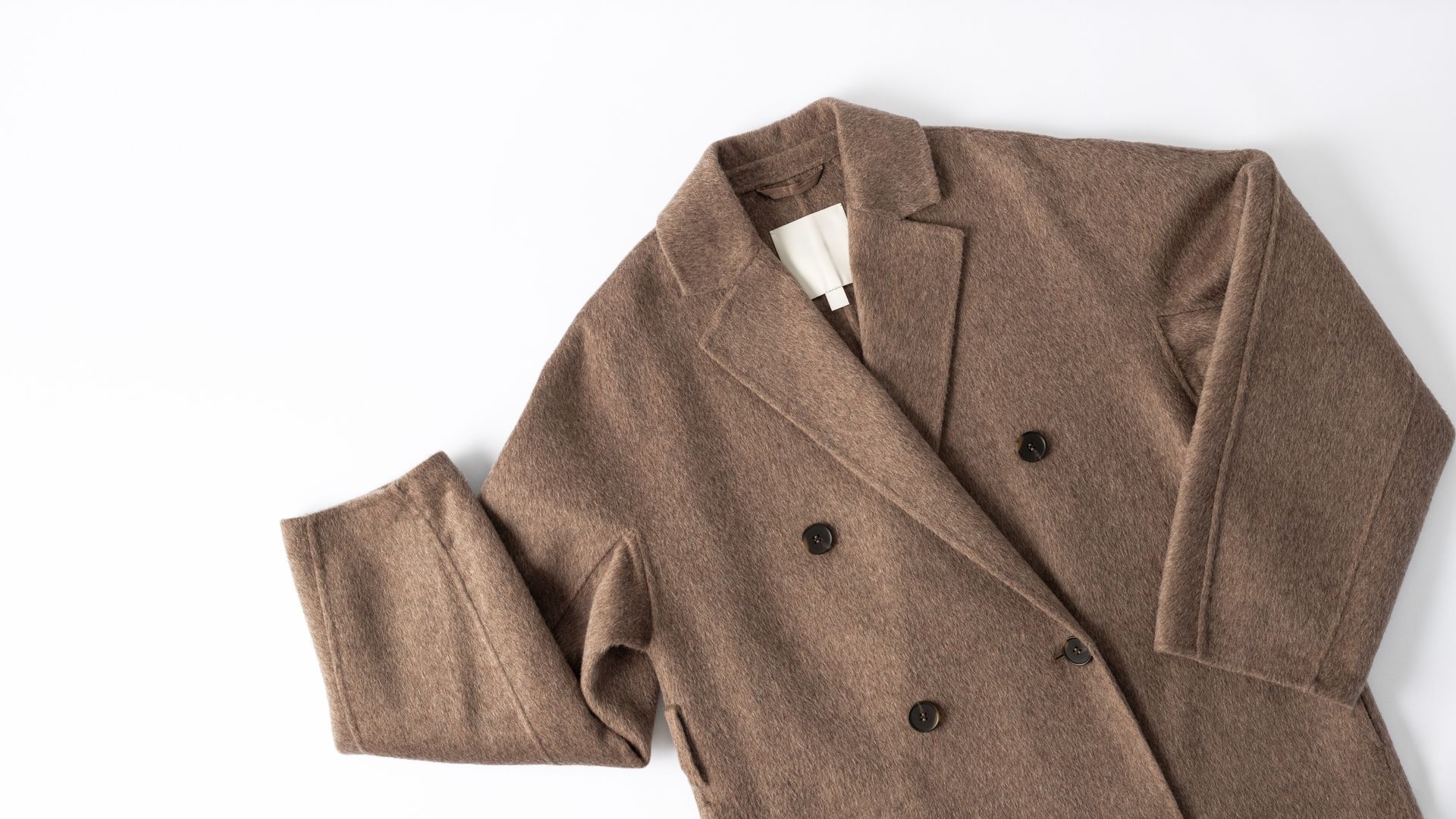 Brown double-breasted coat laid flat on a white background