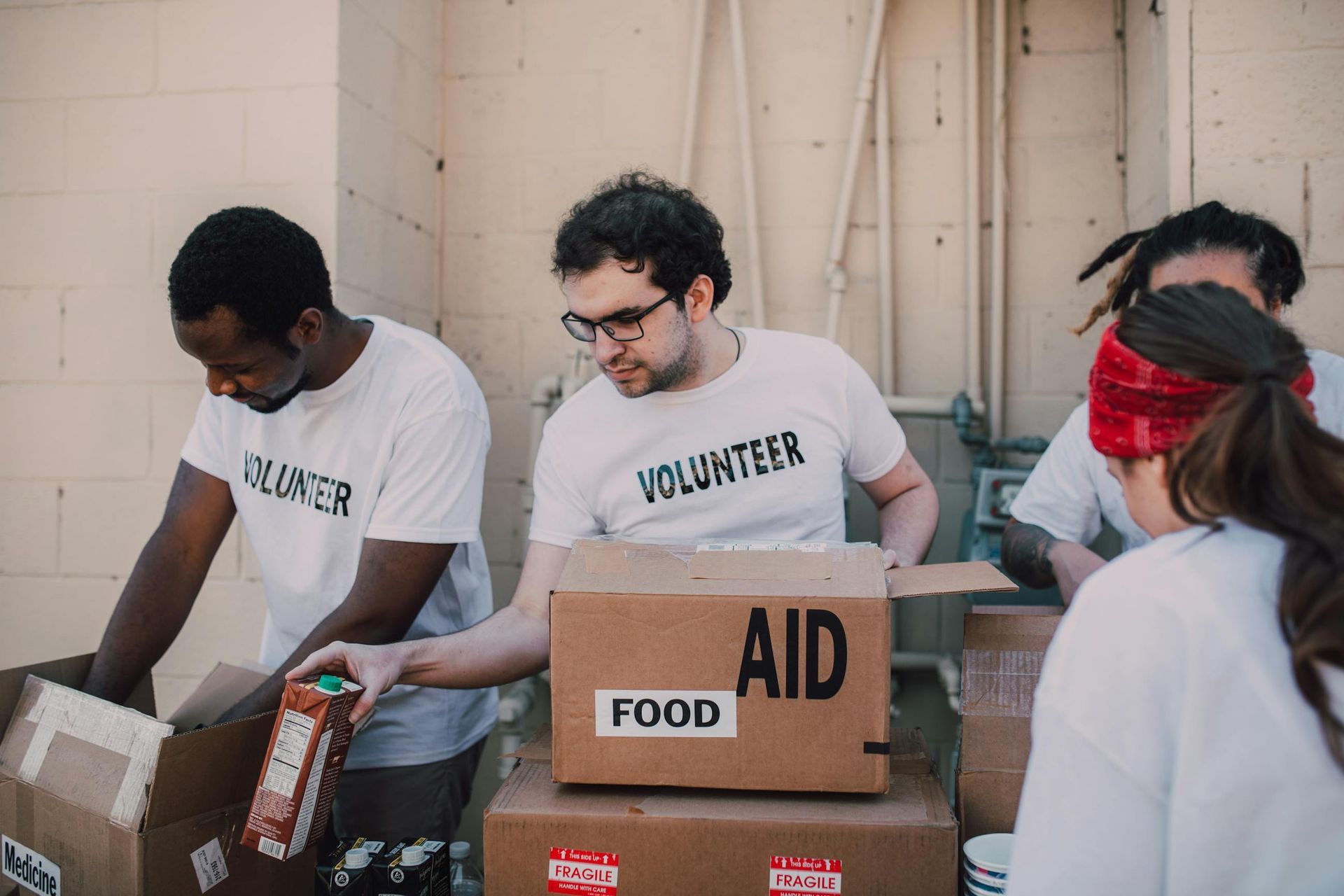Volunteers packing food boxes at an aid distribution station indoors
