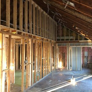 Interior of a house under construction with exposed wooden framing and sloped ceiling.