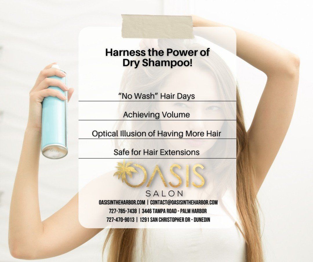 A woman is holding a bottle of dry shampoo in front of her face.