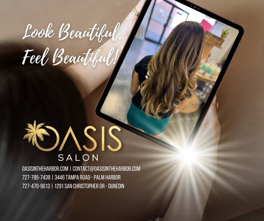 A woman is looking at herself in a mirror at oasis salon.