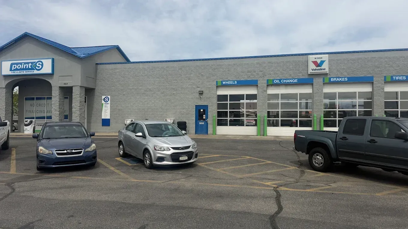 Car dealership service building with three parked vehicles in front on a cloudy day | Jones Complete Car Care