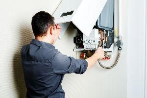 Man Checking the Furnace — Vashon, WA — Vashon Heating & Cooling Man Checking the Furnace — Vashon, WA — Vashon Heating & Cooling