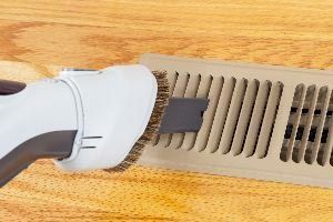 Cleaning Heater Vent with Vacuum — Vashon, WA — Vashon Heating & Cooling Cleaning Heater Vent with Vacuum — Vashon, WA — Vashon Heating & Cooling
