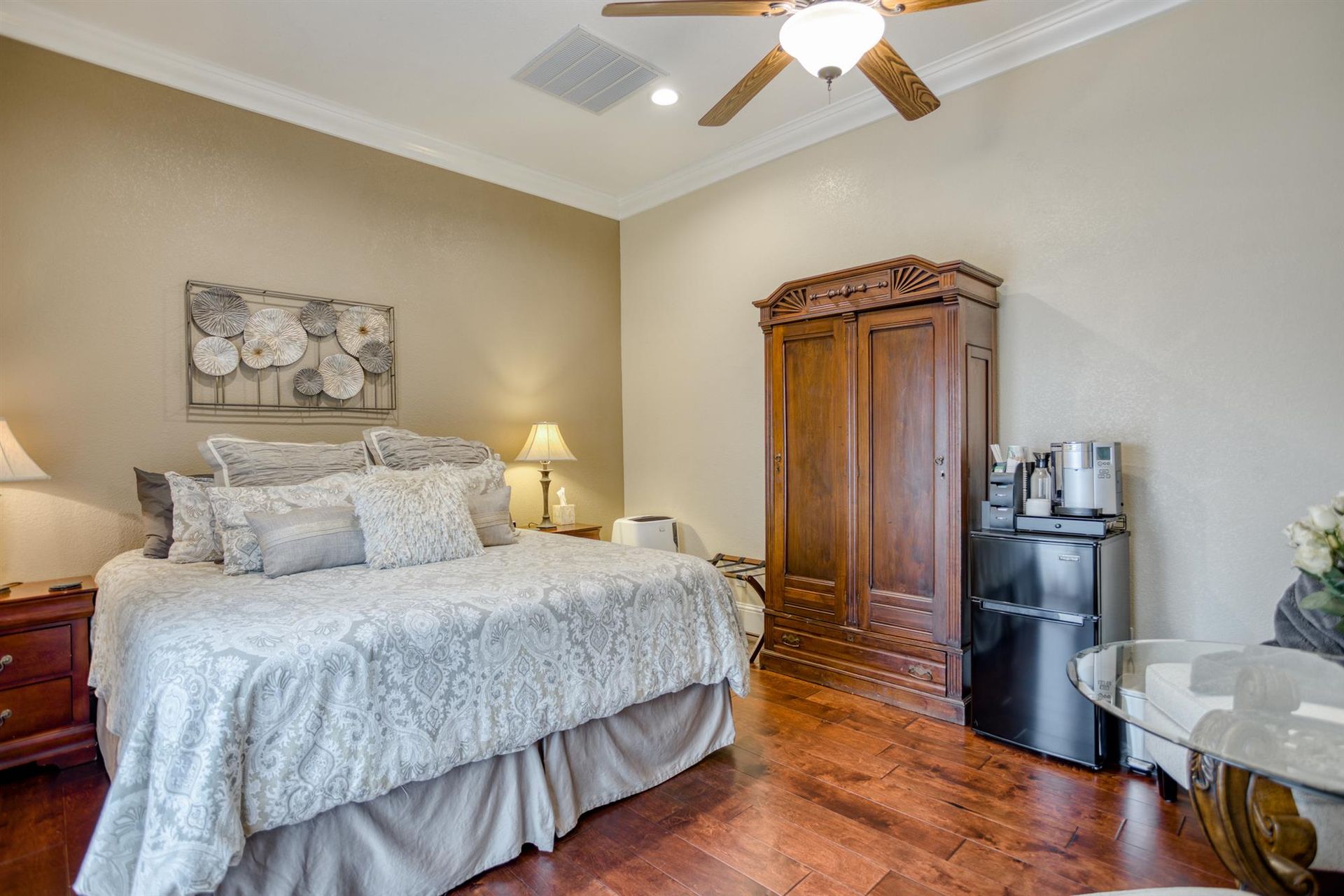 A bedroom with a king size bed and a ceiling fan.