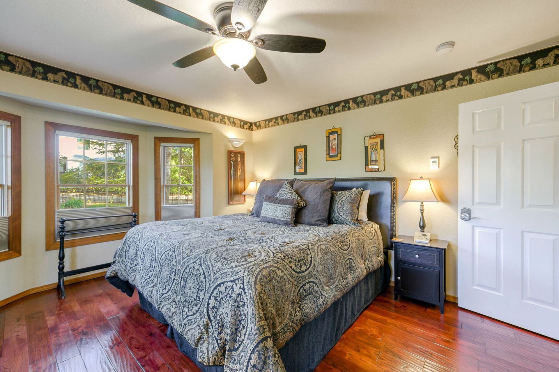 A bedroom with a king size bed and a ceiling fan.