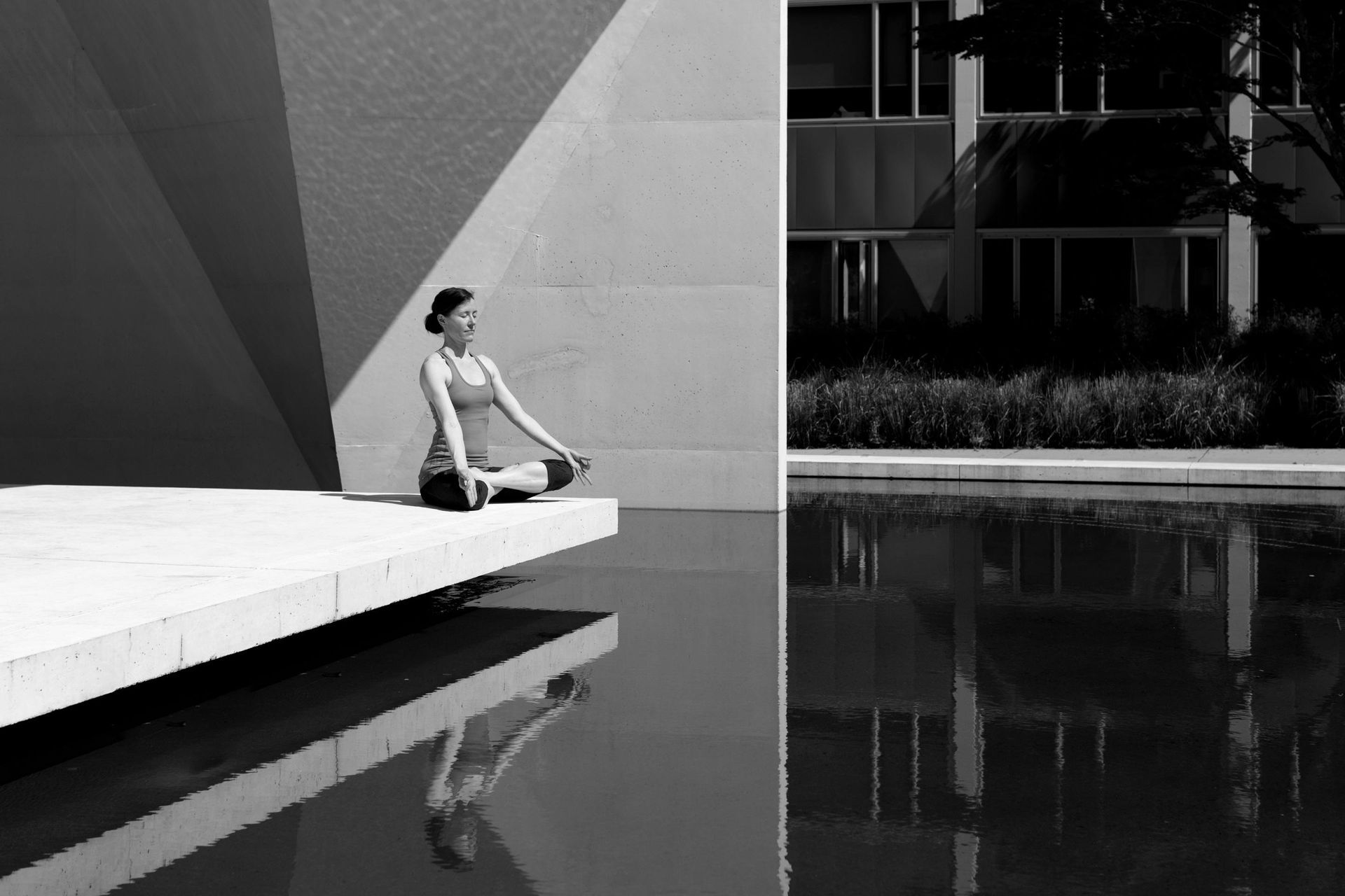 A female corporate professional practising yoga as she focuses on her mental health.