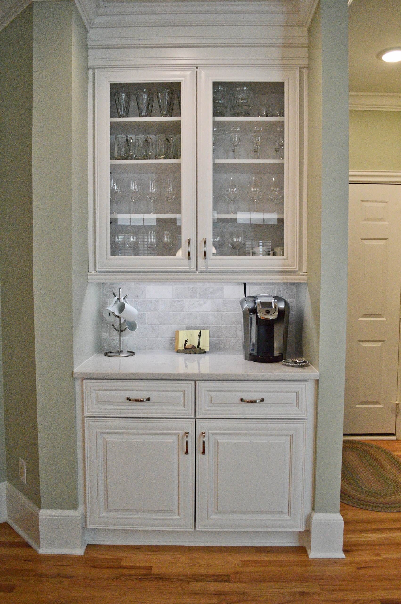 A kitchen with white cabinets and a coffee maker