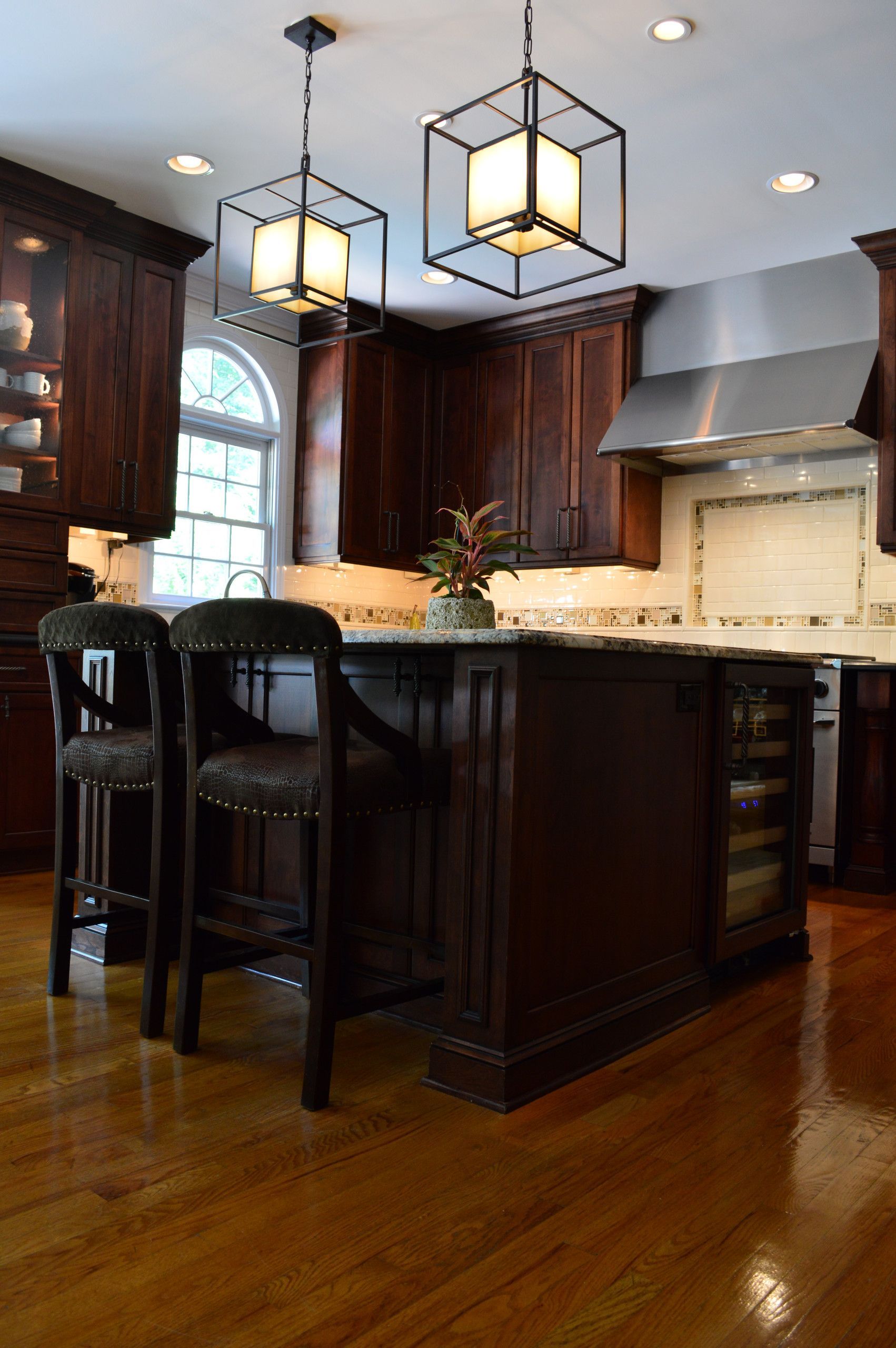 A kitchen with a large island and two stools
