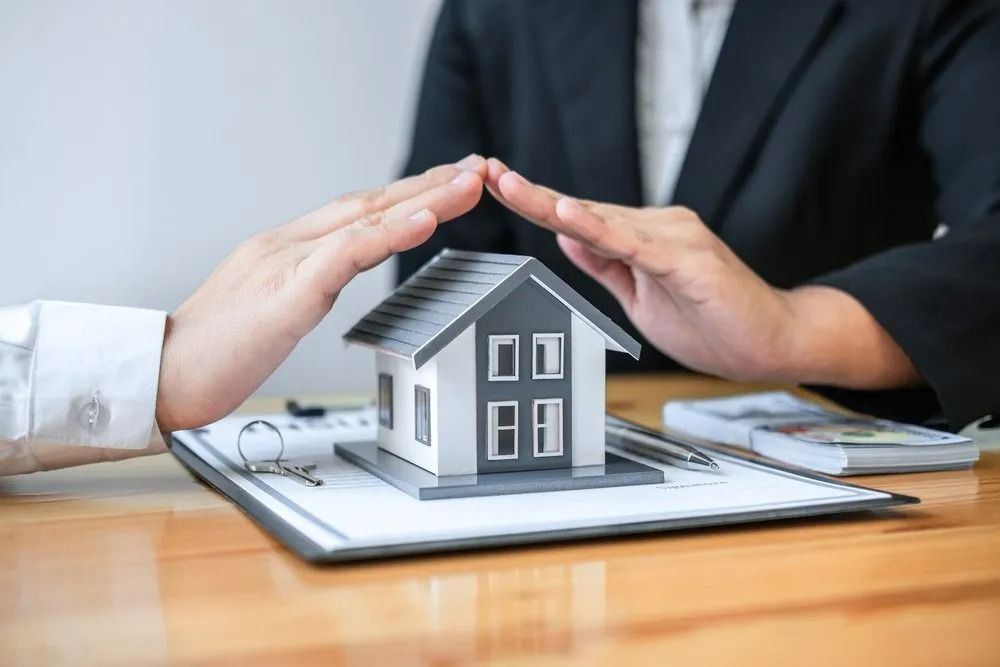 Hands Protecting Small House Model Symbolizing Home Protection — All Finanz & Insurance Solutions Mackay in Moranbah, QLD