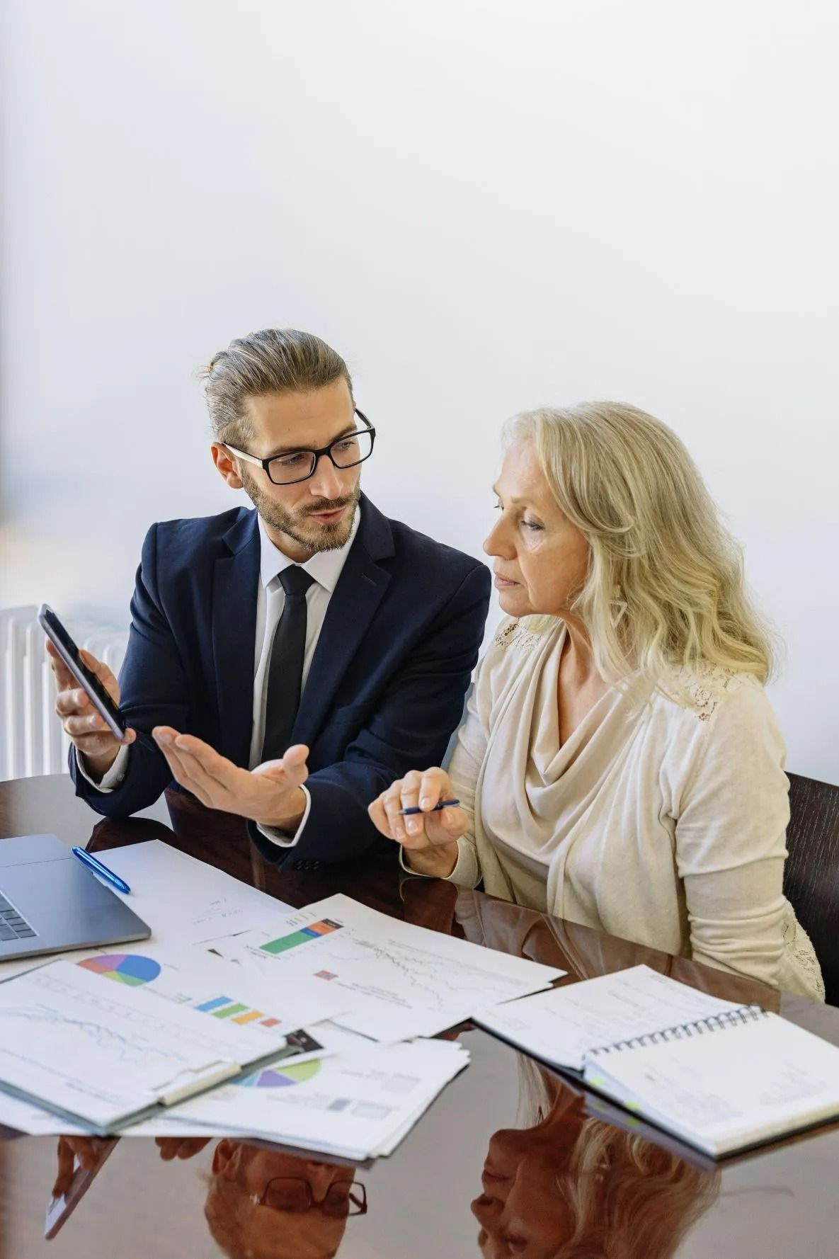 Man in Suit Showing Tablet to Woman Reviewing Documents — All Finanz & Insurance Solutions Mackay in Airlie Beach, QLD