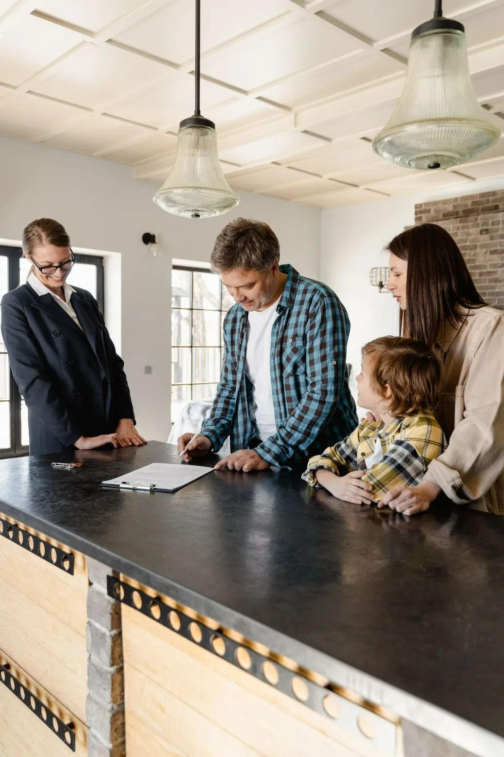 Family Signing Paperwork with Realtor in Modern Kitchen — All Finanz & Insurance Solutions Mackay in North Mackay, QLD