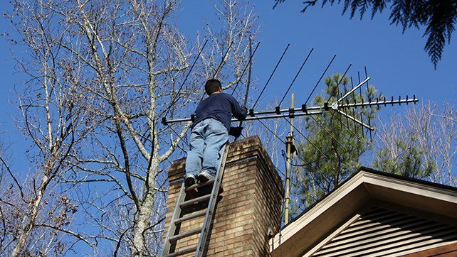 Man Sweeping Chimney — Livermore, CA — Charlie Dunn & Sons Man Sweeping Chimney — Livermore, CA — Charlie Dunn & Sons
