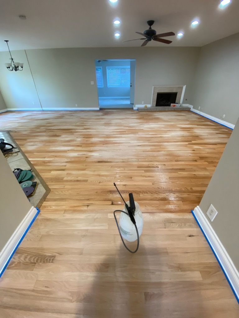 A spray bottle is sitting on a wooden floor in a living room.