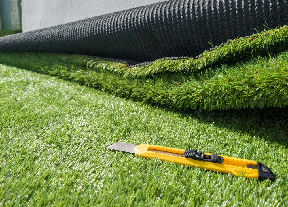 a cutter sit in an artificial turf to be installed in the yard