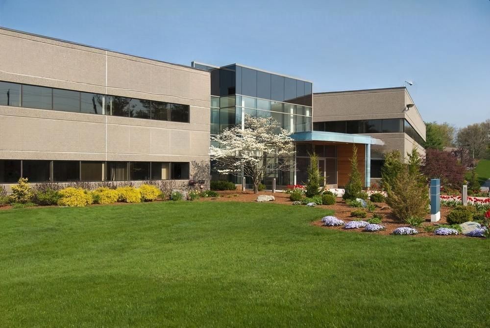 a large building with a lush green lawn in front of it