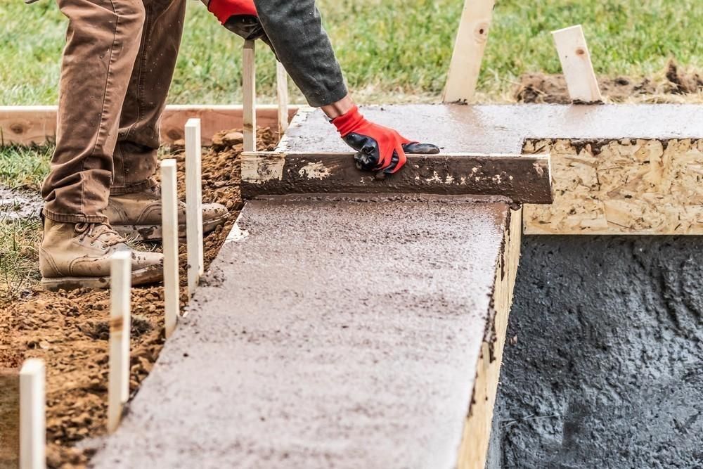 a man is using a level to check the level of a sidewalk .