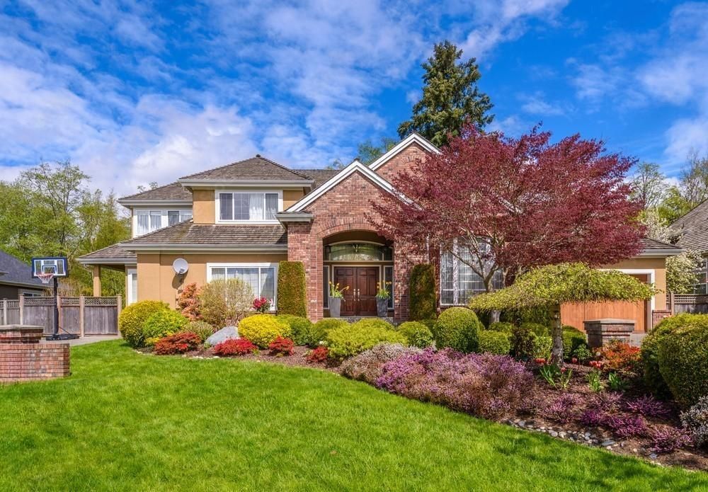 a large brick house with a lush green lawn in front of it .