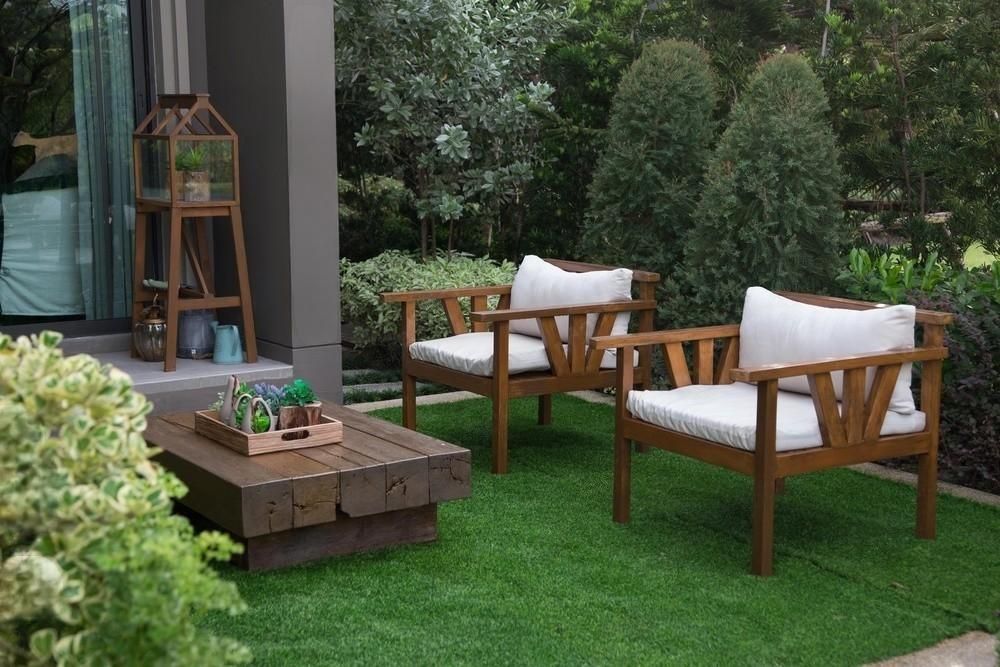 there are two chairs and a table in the backyard .