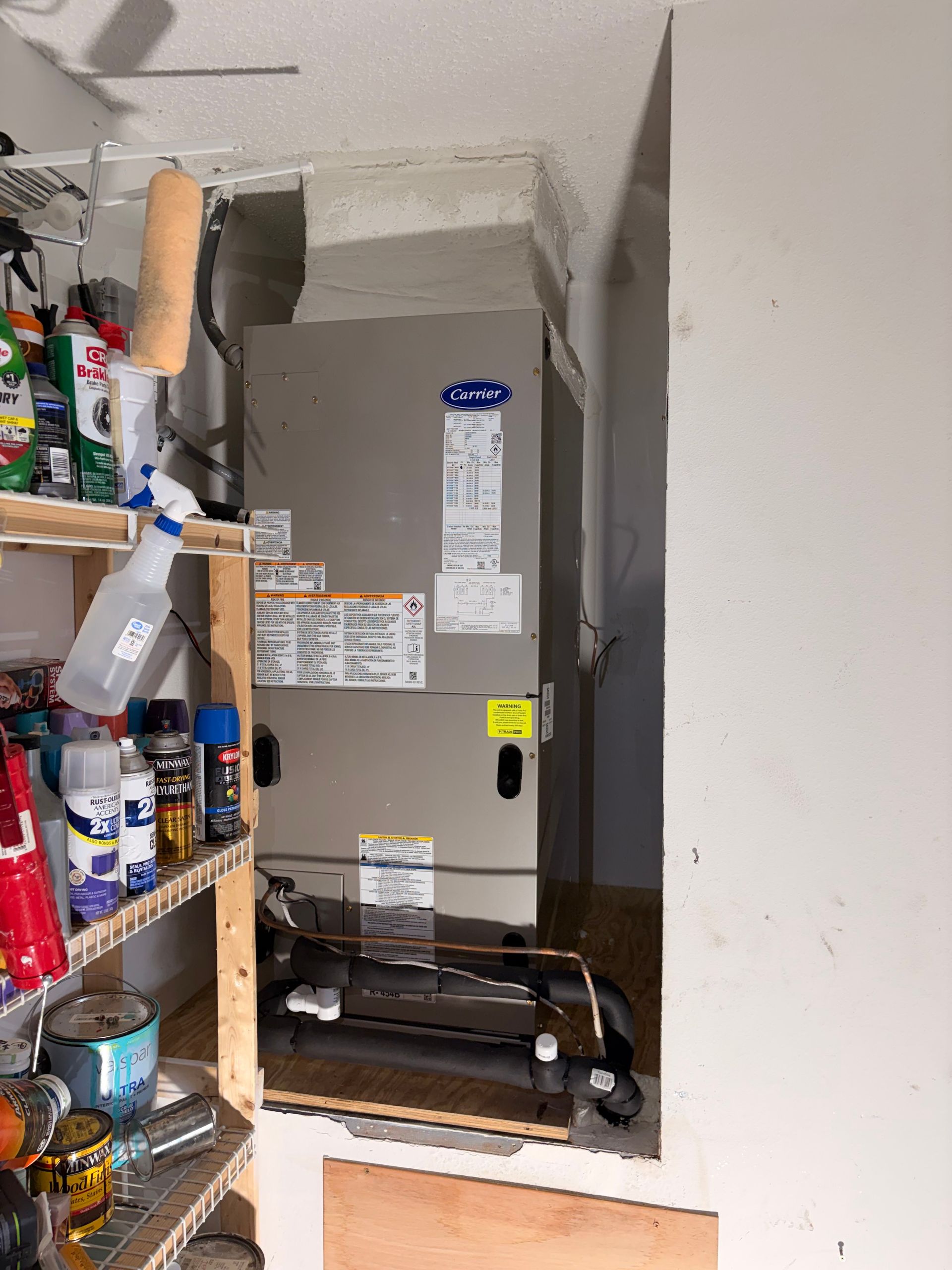 Pantry shelves beside a gray furnace and ductwork in a narrow utility closet.