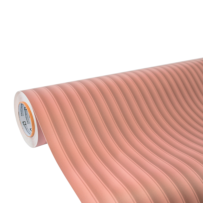 Um rolo de papel contact rosa claro com uma textura canelada vertical, visto de um ângulo.