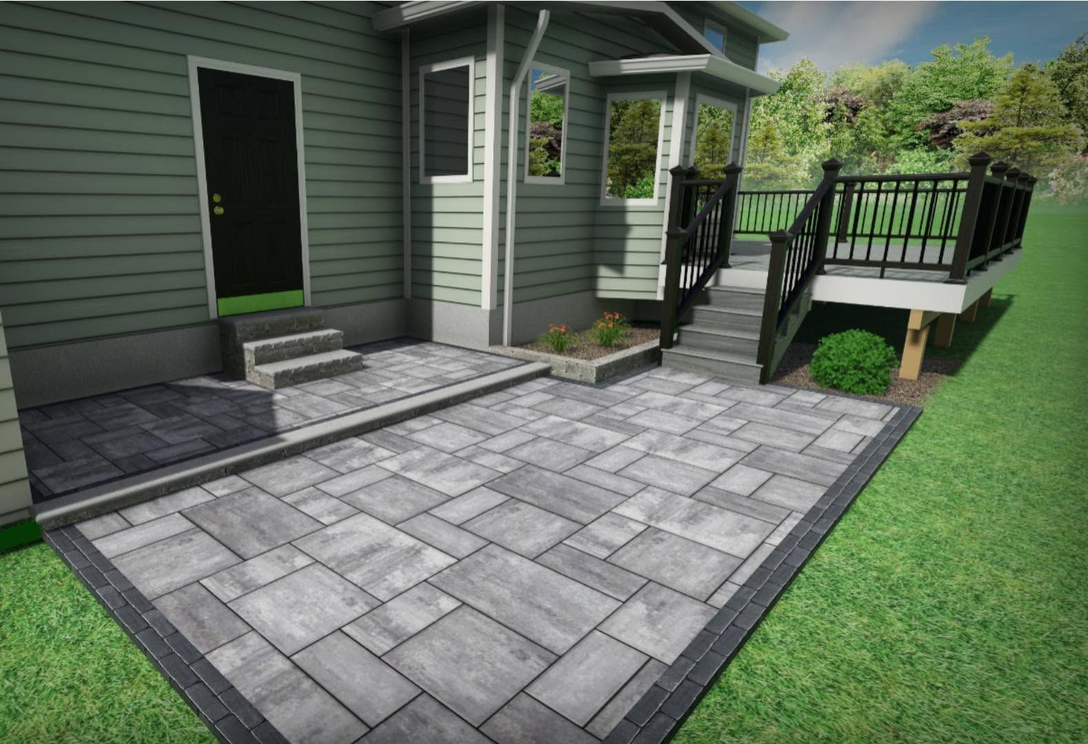 Gray paver patio beside a house, with steps to a small raised deck and green lawn edging the space