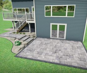 Stone retaining walls and steps terracing a sloped yard beside a driveway and house.