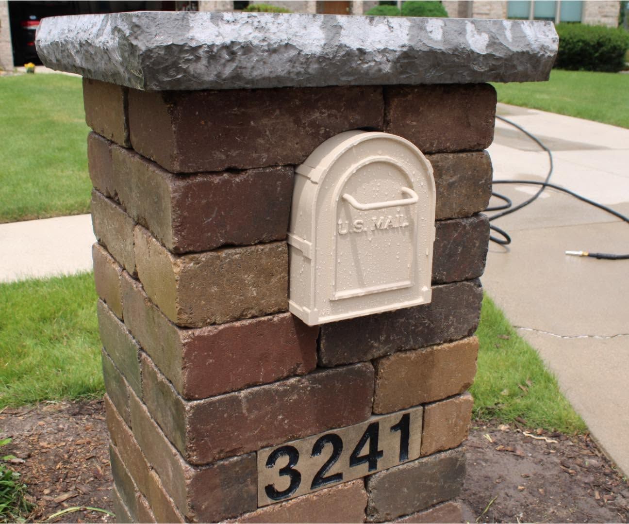 Brick mailbox pillar with white mailbox and house number 3241 beside a driveway