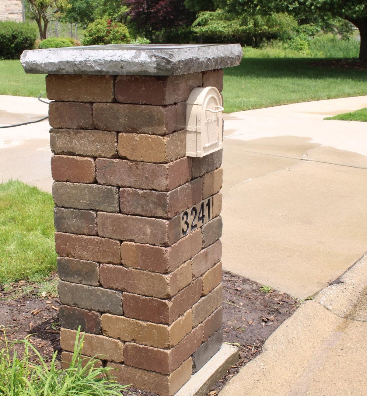 Brick mailbox pillar with house number 3241 beside a sidewalk and driveway