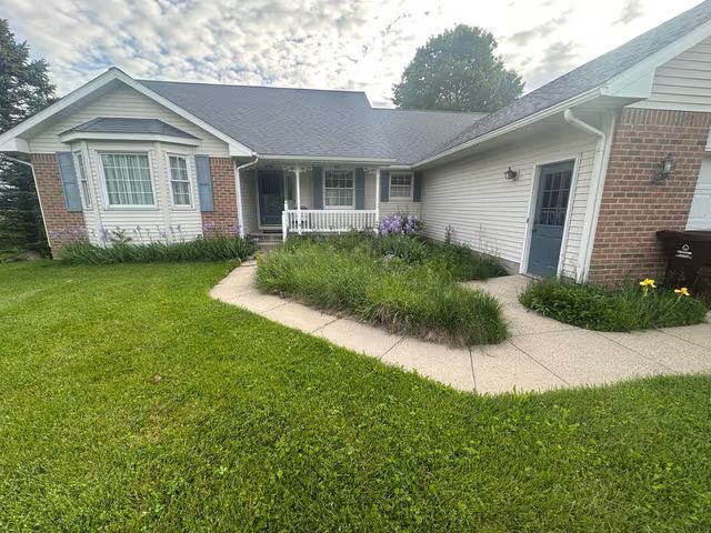 Single-story brick house with a curved walkway and front lawn.