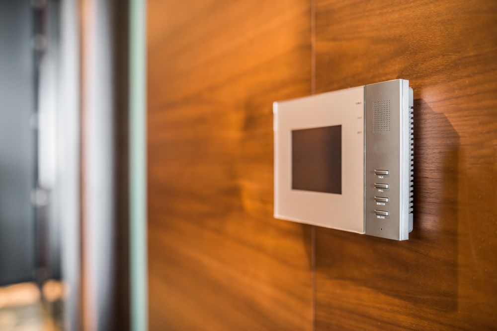 Wall-Mounted White Intercom with Screen on A Wooden Wall — Terrace Locksmiths in Cessnock, NSW