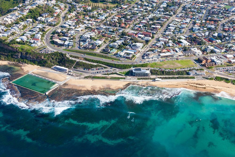 Aerial View of A Coastal Town with A Beach, Turquoise Ocean Waves — Terrace Locksmiths in Raymond Terrace, NSW