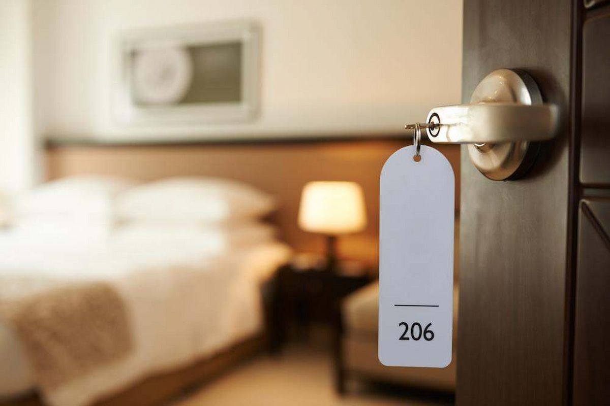 Hotel Room Door With White Hanging Tag Labeled 206, Bed and Lamp — Terrace Locksmiths in Raymond Terrace, NSW