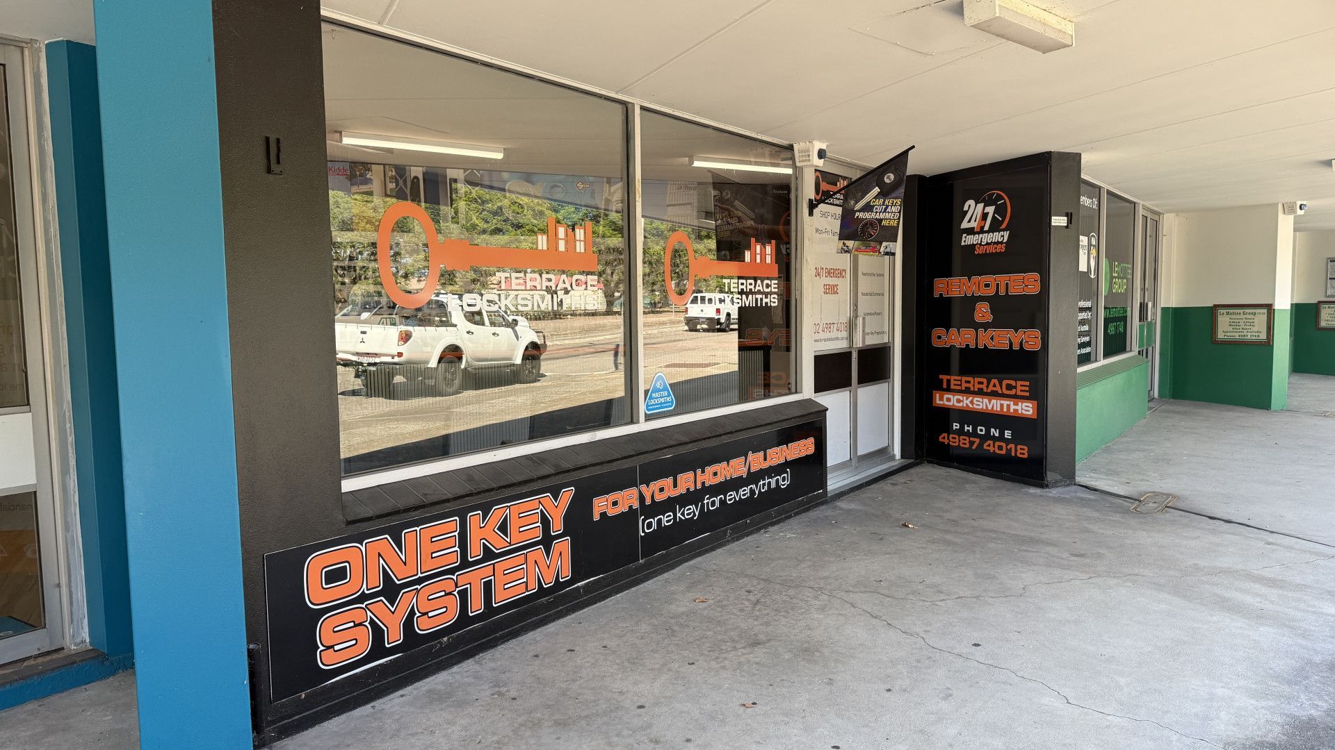 Glass-Front Storefront with Orange and Black Signage — Terrace Locksmiths in Raymond Terrace, NSW