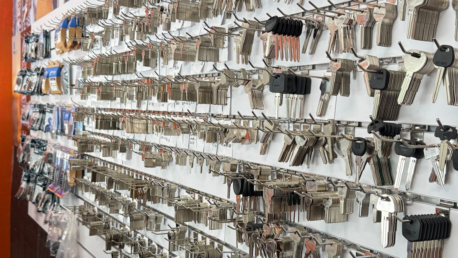 Rows of assorted keys hanging on wall hooks in a key shop or hardware store