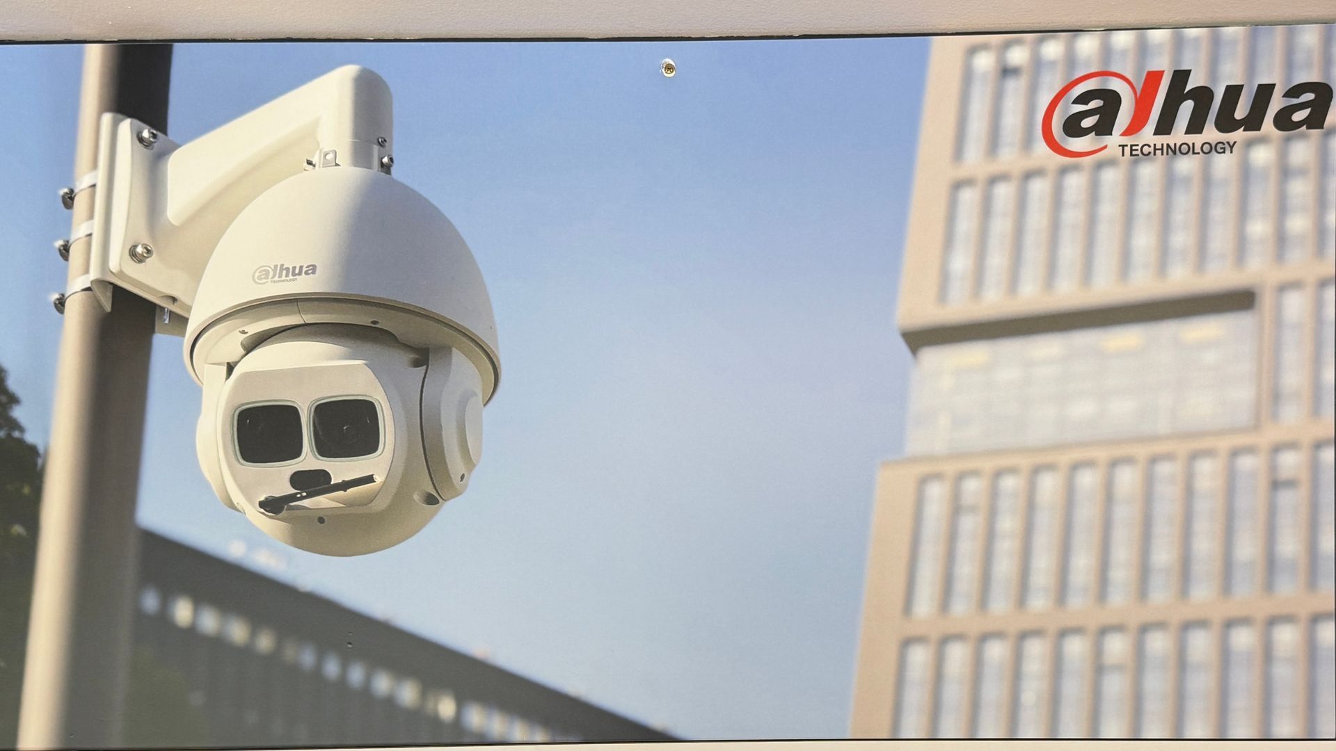 Security camera mounted on a building, showing a stylized face on its lens with a Dahua logo in the background — Terrace Locksmiths in Raymond Terrace, NSW