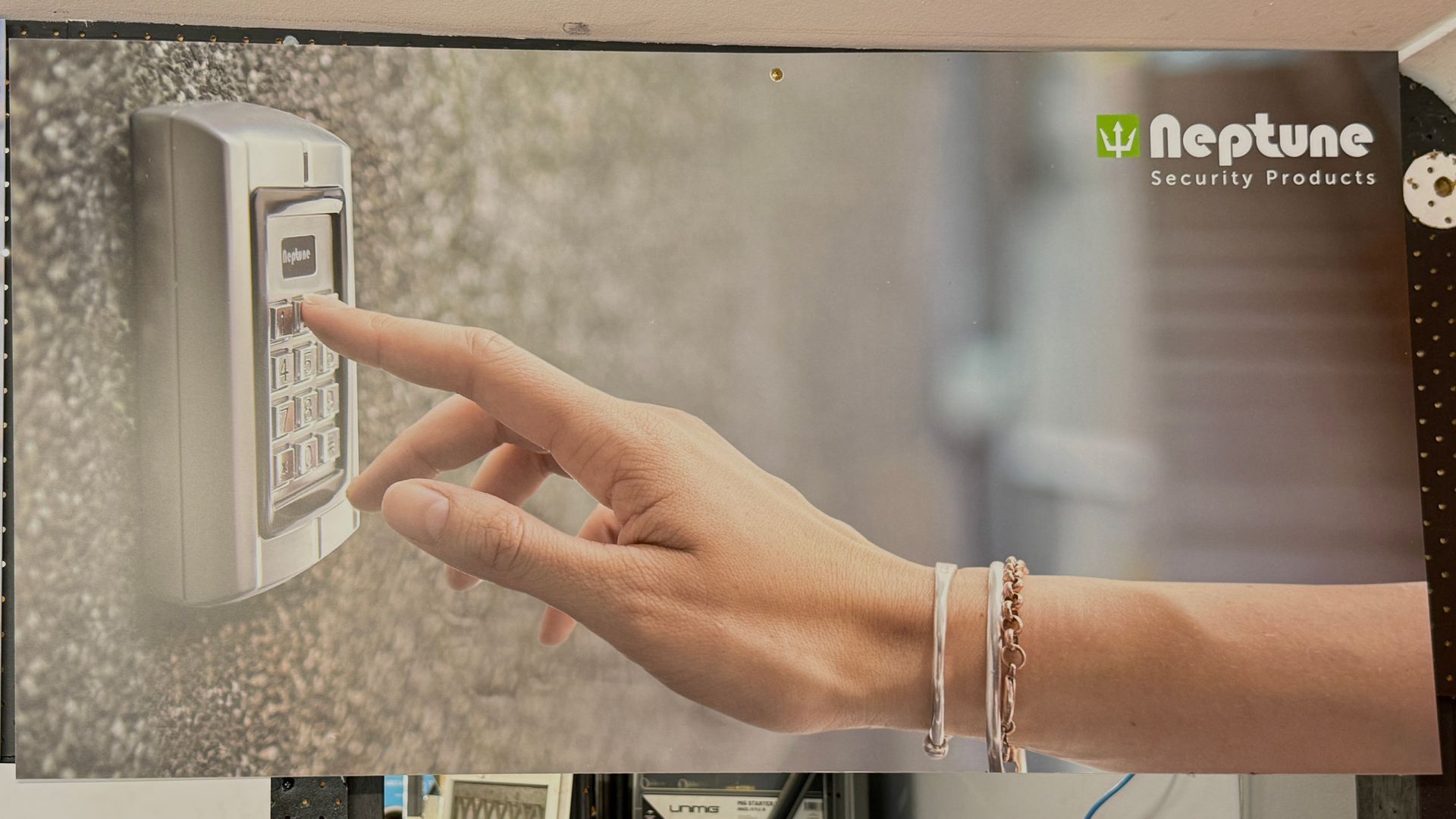 Hand entering a code on a wall-mounted keypad lock beside a door — Terrace Locksmiths in Raymond Terrace, NSW