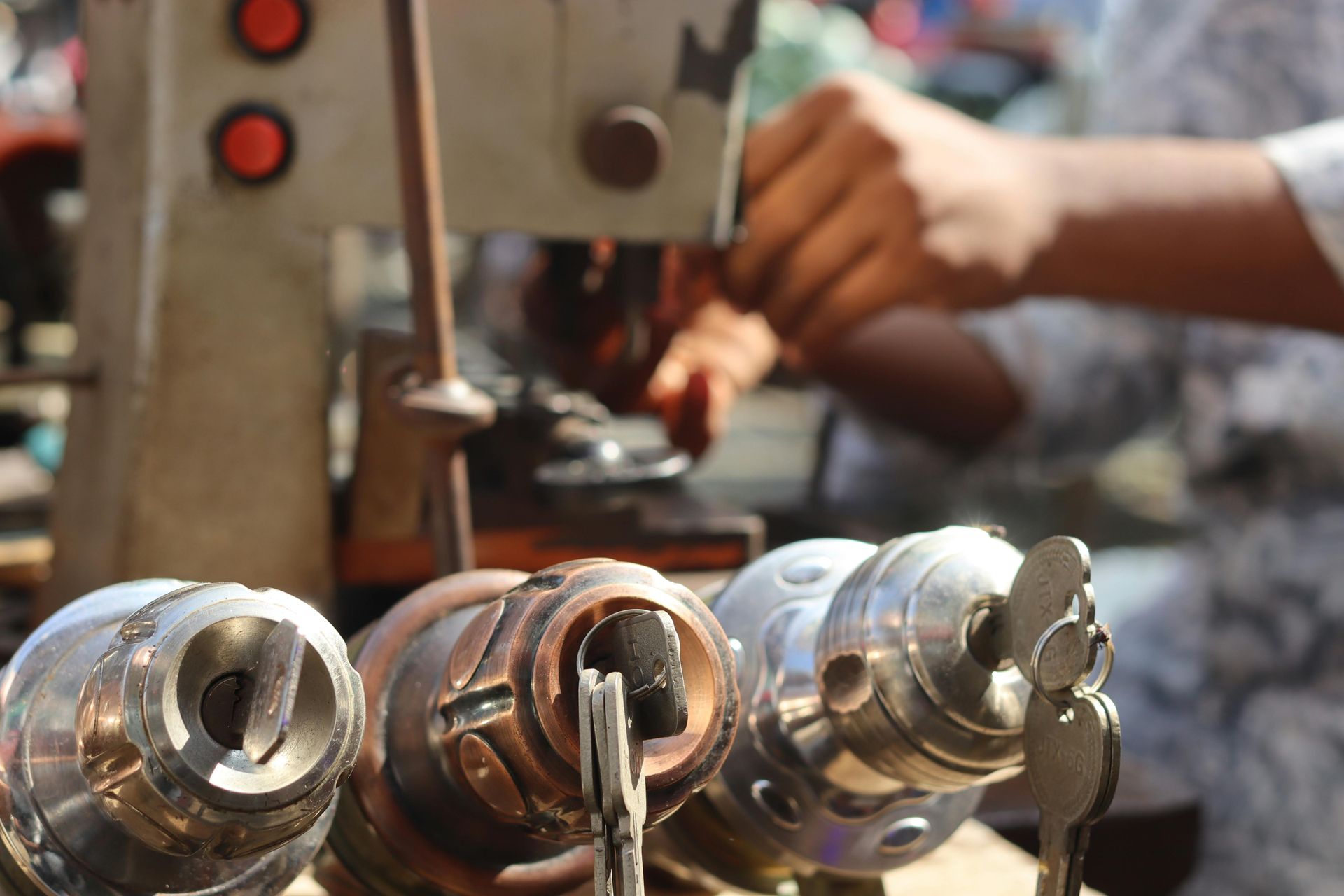 Metal parts on a machine table with a person adjusting equipment — Terrace Locksmiths in Raymond Terrace, NSW