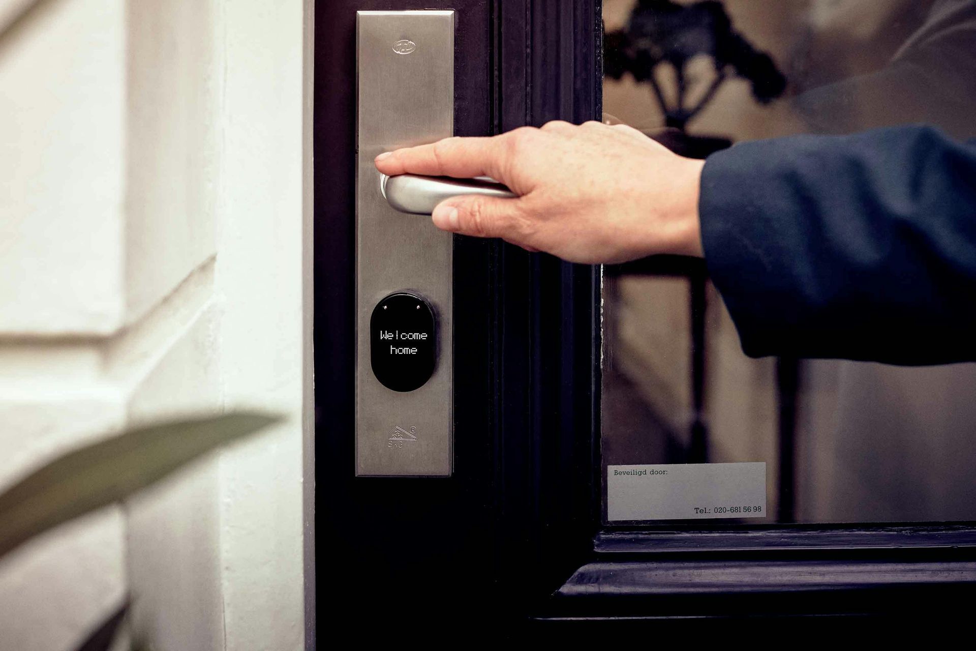 Hand Pressing a Silver Doorbell Beside a Dark Doorway — Terrace Locksmiths in Merewether, NSW