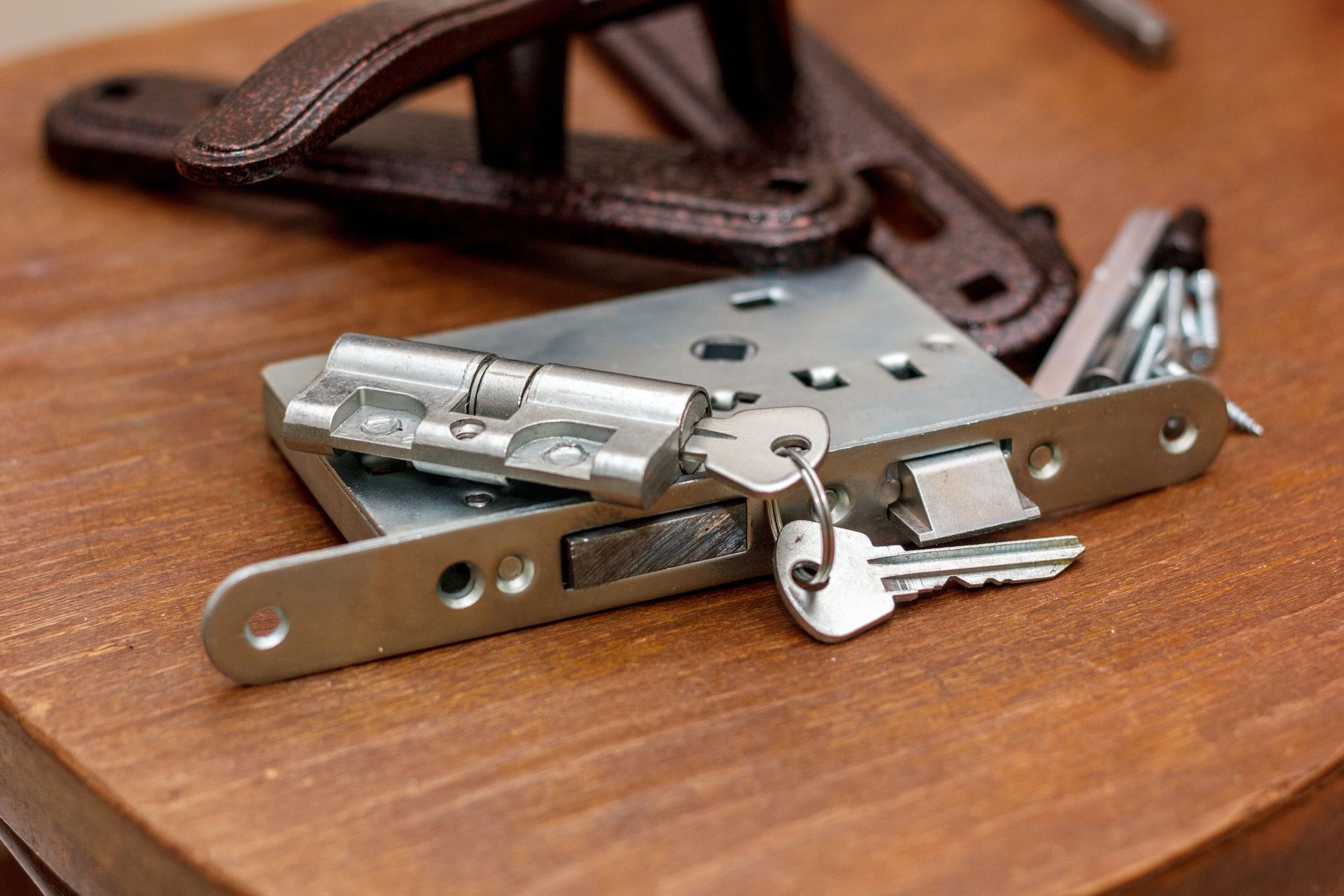 Metal Door Lock Hardware and Keys on a Wooden Surface — Terrace Locksmiths in Merewether, NSW