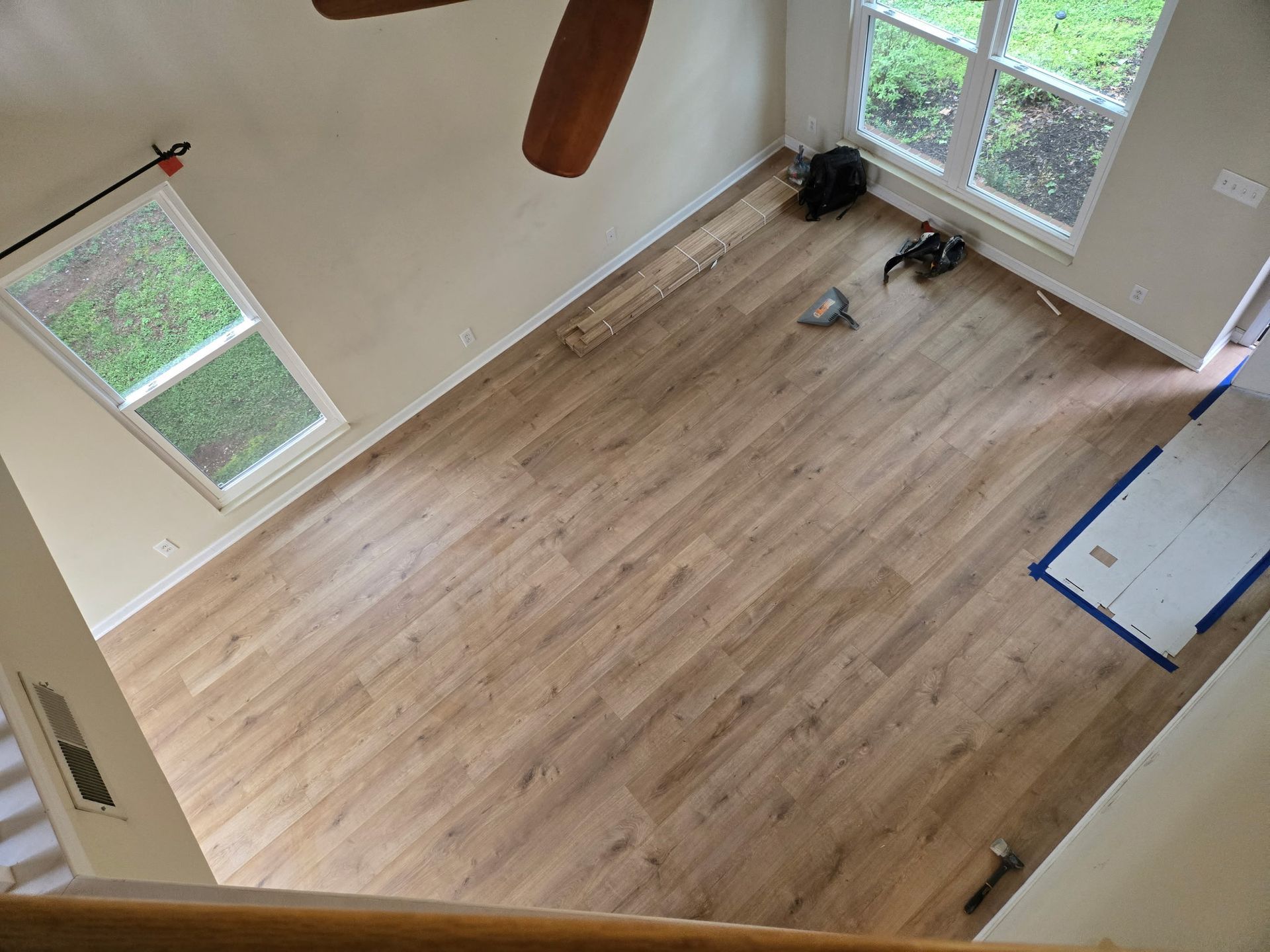 An aerial view of a living room with hardwood floors and a ceiling fan.