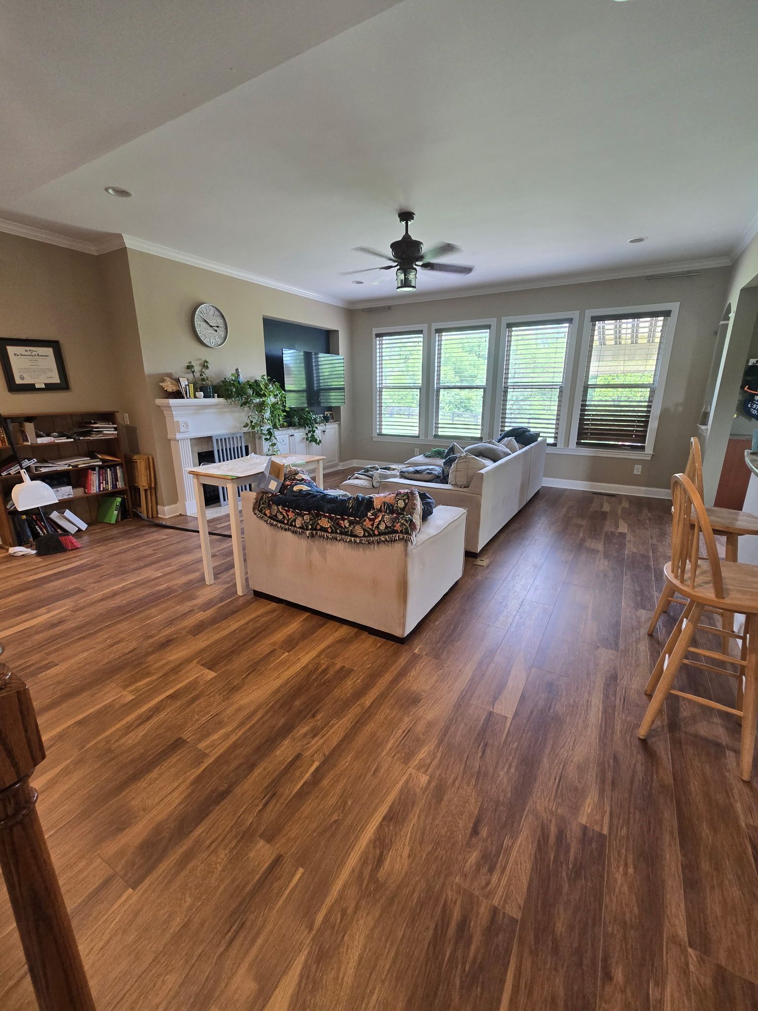 Living room with sectional sofa, fireplace, windows, and wood flooring.