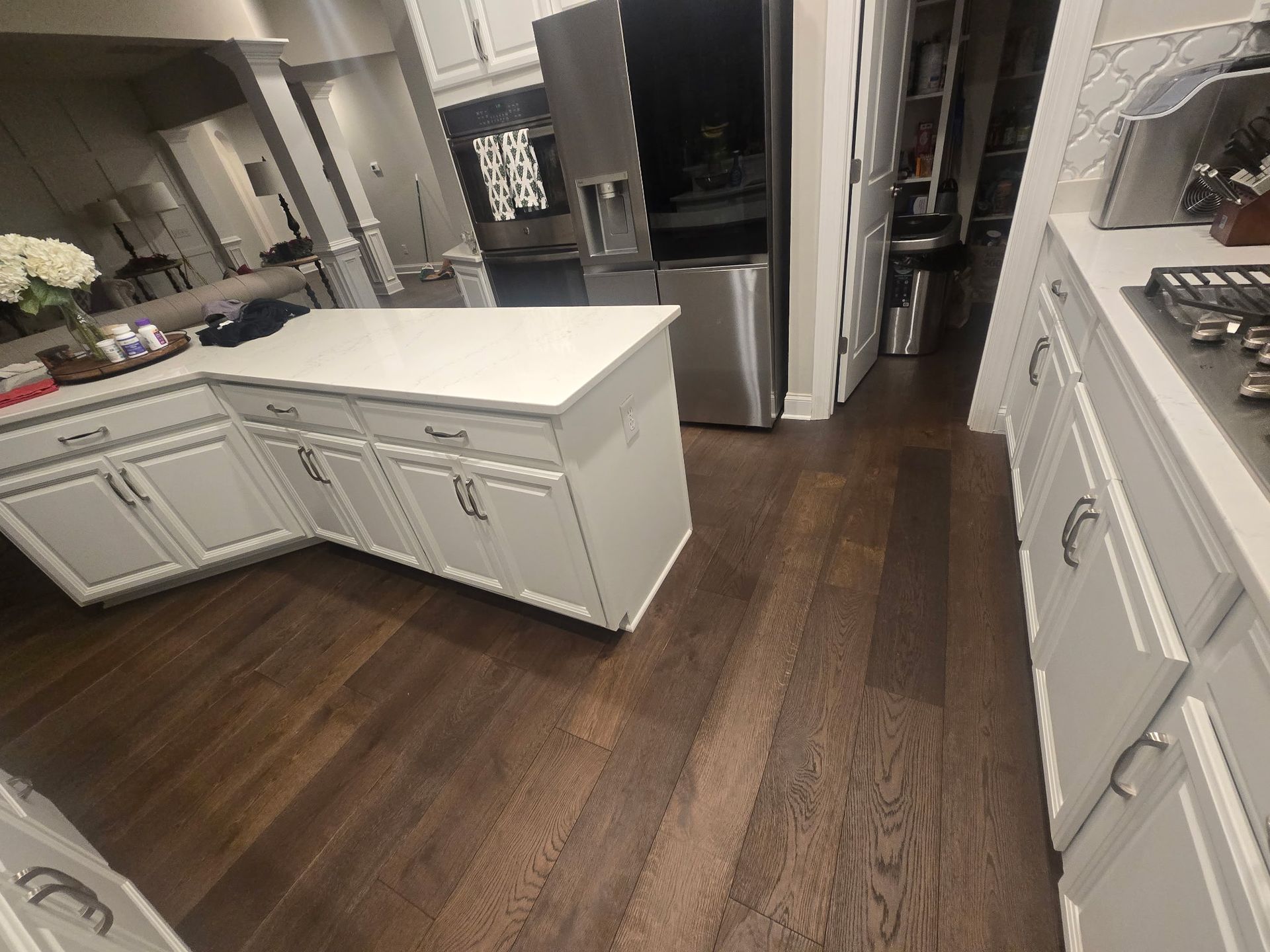 Modern kitchen with white cabinets, central island, and dark wood flooring