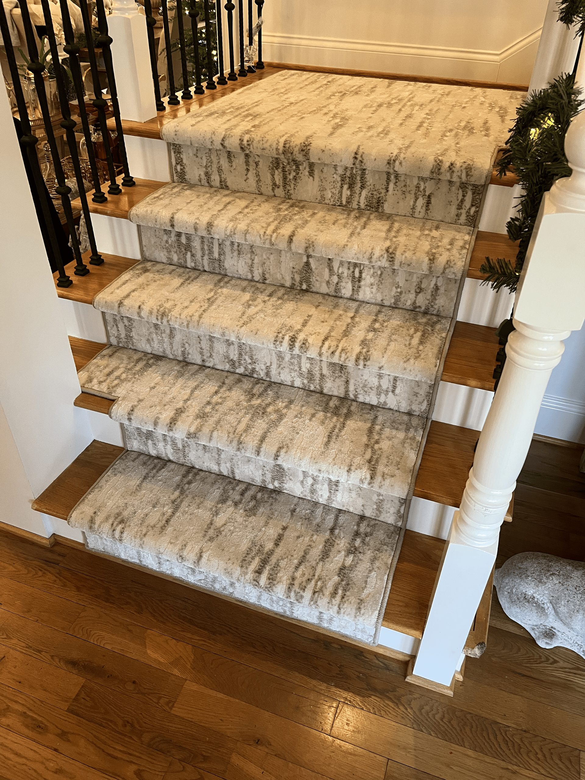 Carpeted staircase with white banisters and dark wood flooring in a home interior