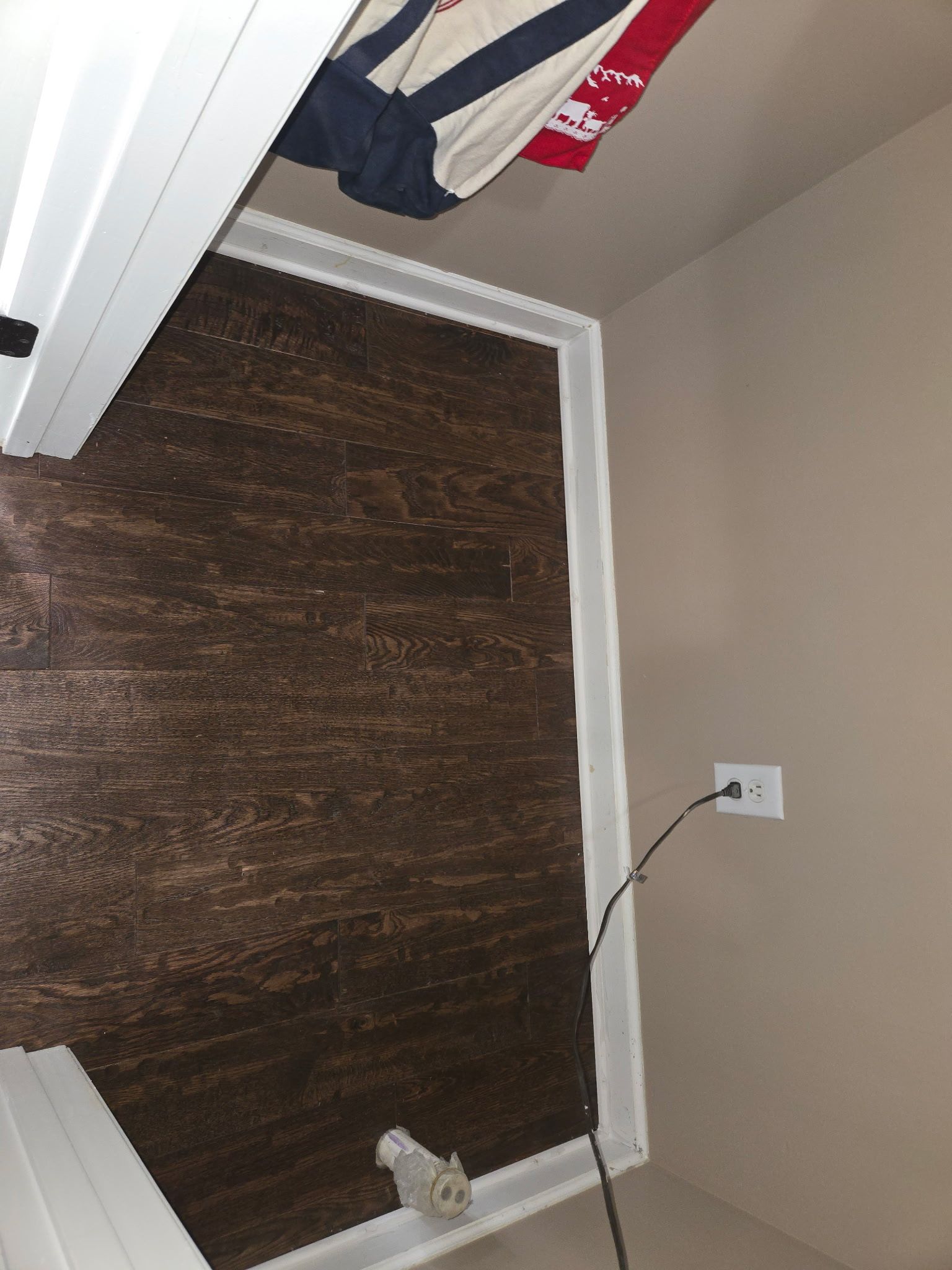 Small room with a brown window blind, beige walls, and a dangling cord near an outlet.