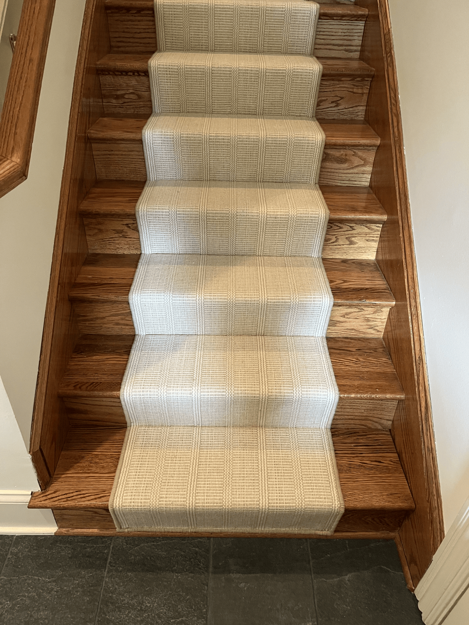 Carpeted staircase with wooden sides and a runner, viewed from the bottom up.
