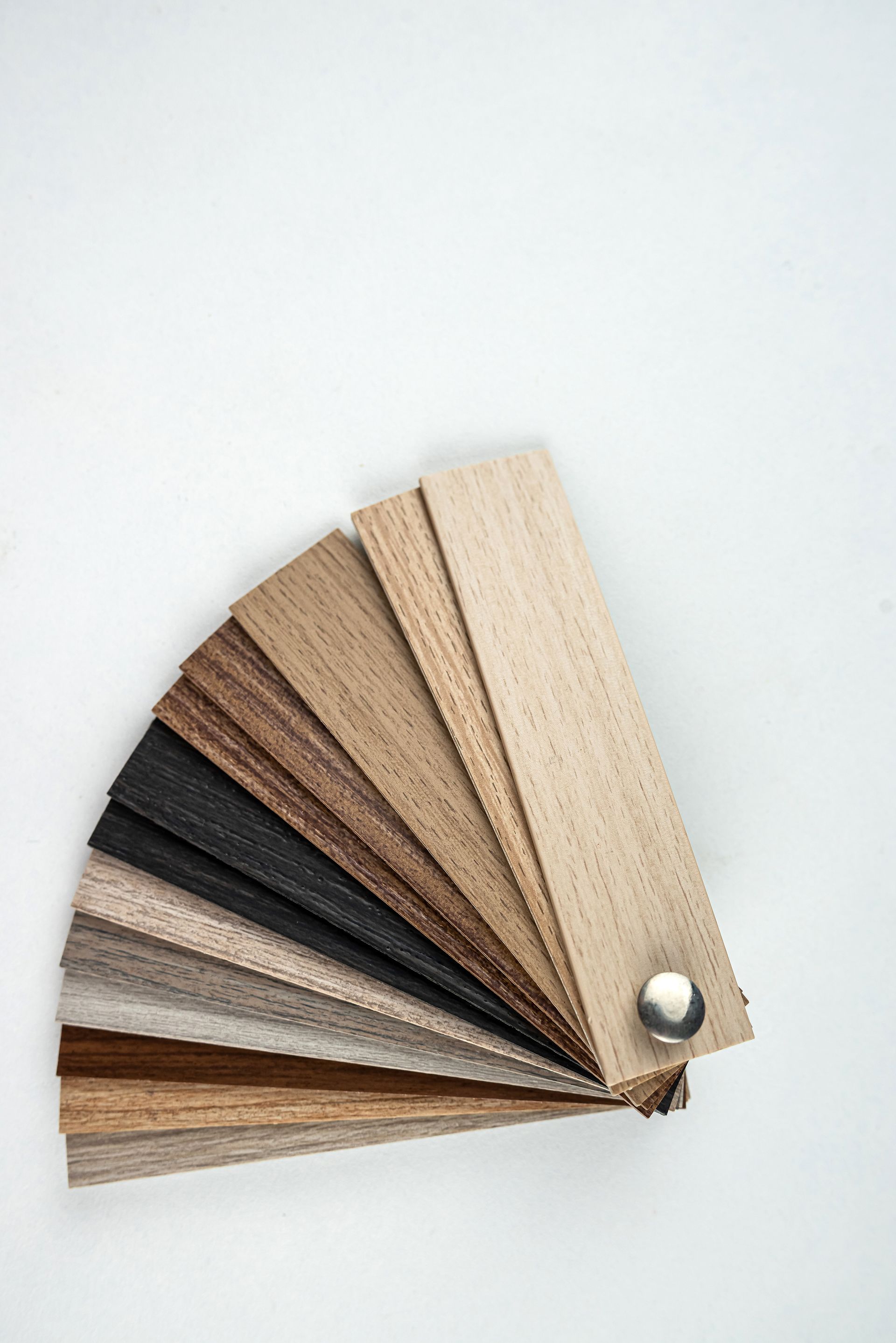 Wooden color swatches fanned out on a white background, showing various shades of wood.
